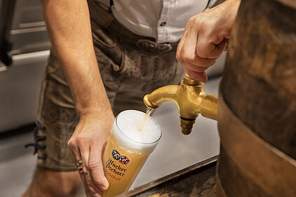 Bier wird aus dem Zapfhahn in ein Glas gezapft im Maximilians Berlin